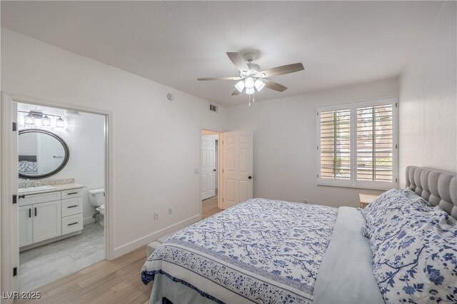 75 N Valle Verde Dr Unit 211, Henderson, NV 89074 - bedroom featuring light wood-style floors, a sink, ensuite bath, ceiling fan, and baseboards