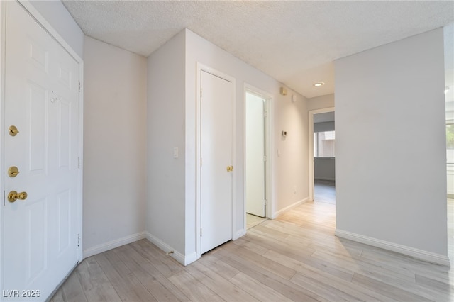 6871 Tamarus St Unit 204, Las Vegas, NV 89119 - corridor featuring light wood-style floors, baseboards, and a textured ceiling
