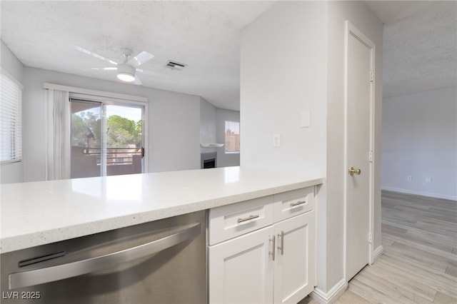 6871 Tamarus St Unit 204, Las Vegas, NV 89119 - kitchen featuring stainless steel dishwasher, white cabinets, ceiling fan, a textured ceiling, and baseboards