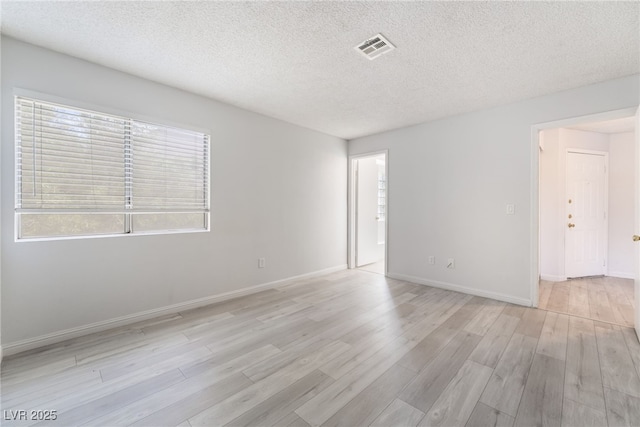 6871 Tamarus St Unit 204, Las Vegas, NV 89119 - unfurnished room with light wood finished floors, a textured ceiling, and baseboards