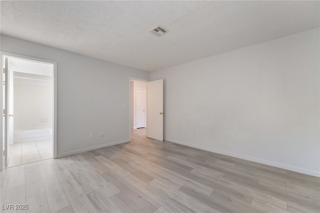 6871 Tamarus St Unit 204, Las Vegas, NV 89119 - empty room featuring light wood-style floors, a textured ceiling, and baseboards