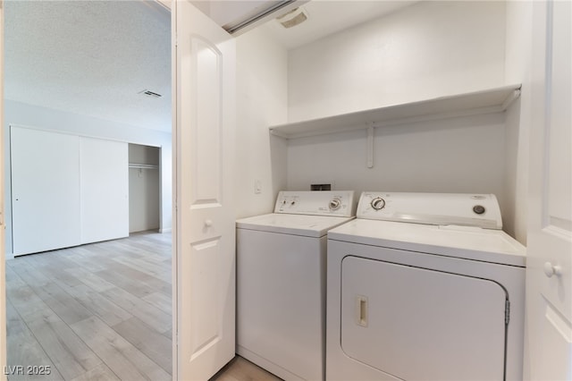 6871 Tamarus St Unit 204, Las Vegas, NV 89119 - laundry room with separate washer and dryer and light wood-style floors