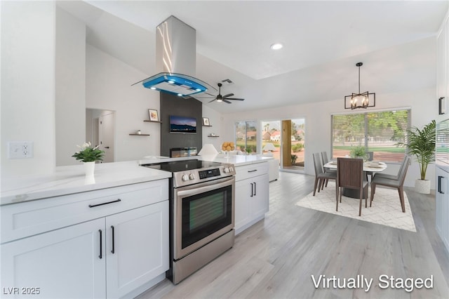 2553 Showcase Dr, Las Vegas, NV 89134 - kitchen with electric range, lofted ceiling, island exhaust hood, white cabinets, and a chandelier