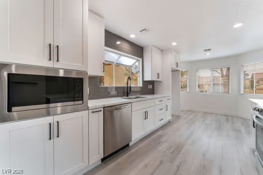 2553 Showcase Dr, Las Vegas, NV 89134 - kitchen with appliances with stainless steel finishes, a sink, white cabinetry, plenty of natural light, and recessed lighting