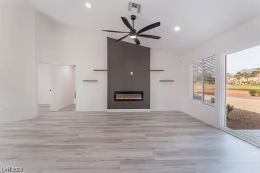2553 Showcase Dr, Las Vegas, NV 89134 - unfurnished living room with vaulted ceiling, a ceiling fan, wood finished floors, a fireplace, and recessed lighting