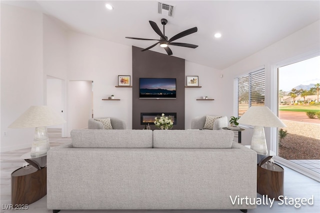 2553 Showcase Dr, Las Vegas, NV 89134 - living area featuring vaulted ceiling, wood finished floors, a ceiling fan, a fireplace, and recessed lighting