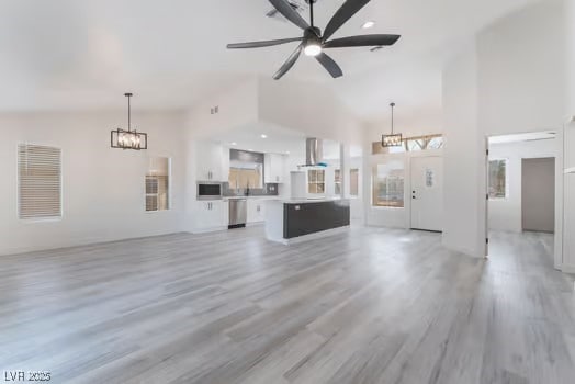 2553 Showcase Dr, Las Vegas, NV 89134 - unfurnished living room featuring a chandelier, high vaulted ceiling, light wood finished floors, and ceiling fan