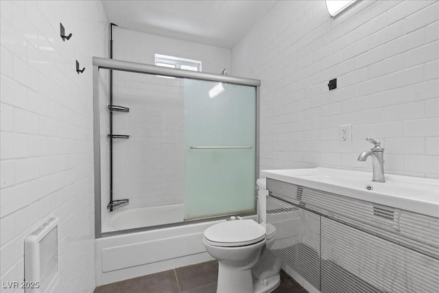 3971 Arlberg Way, Mount Charleston, NV 89124 - bathroom with tile walls, shower / bath combination with glass door, vanity, tile patterned floors, and toilet