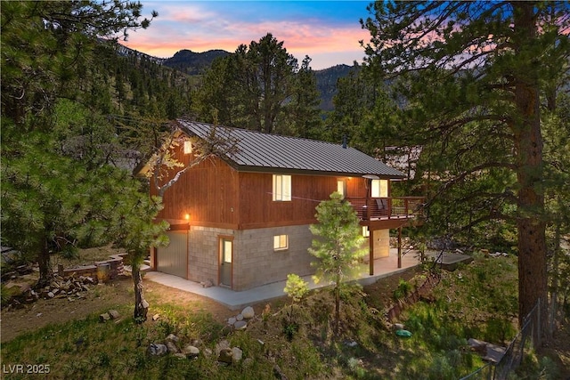 3971 Arlberg Way, Mount Charleston, NV 89124 - property exterior at dusk featuring a deck, a forest view, and metal roof