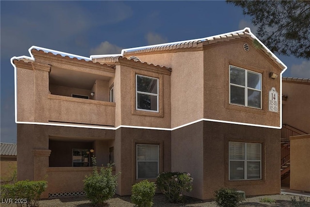 1150 N Buffalo Dr Unit 2025, Las Vegas, NV 89128 - view of home's exterior with stucco siding, a tiled roof, stairs, and a balcony