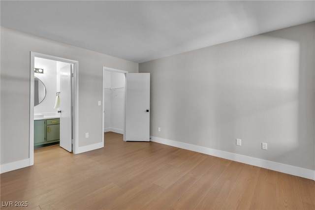 1150 N Buffalo Dr Unit 2025, Las Vegas, NV 89128 - unfurnished bedroom with light wood-type flooring, a walk in closet, connected bathroom, and a closet