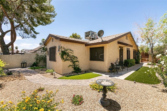 3890 Lancome St, Las Vegas, NV 89115 - view of side of home featuring a patio, stucco siding, and central AC