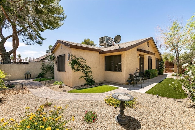 3890 Lancome St, Las Vegas, NV 89115 - view of side of property with a patio, stucco siding, and central AC unit