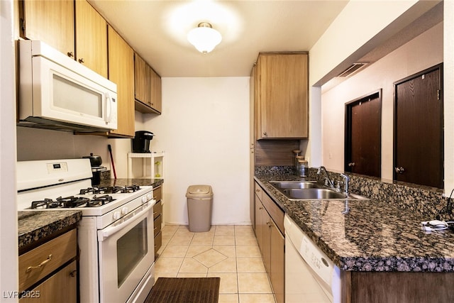 3890 Lancome St, Las Vegas, NV 89115 - kitchen with white appliances, a sink, and light tile patterned floors