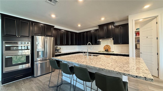 754 Agate Hills St, Las Vegas, NV 89138 - kitchen with appliances with stainless steel finishes, a sink, under cabinet range hood, backsplash, and recessed lighting