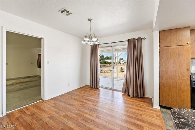 2440 Homestead Rd, Pahrump, NV 89048 - unfurnished dining area featuring light wood-type flooring, a chandelier, and baseboards