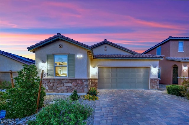 708 Kibbey St, Las Vegas, NV 89178 - mediterranean / spanish home with stone siding, a garage, decorative driveway, stucco siding, and a tiled roof