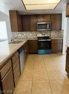 5389 Spencer St, Las Vegas, NV 89119 - kitchen with appliances with stainless steel finishes, decorative backsplash, a sink, and light tile patterned floors