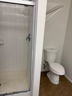 5389 Spencer St, Las Vegas, NV 89119 - full bathroom with tile patterned flooring, a stall shower, baseboards, and toilet