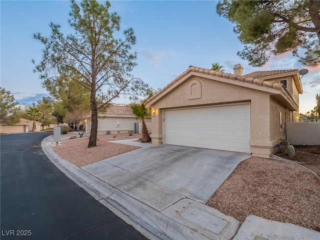 2521 Seascape Dr, Las Vegas, NV 89128 - mediterranean / spanish house featuring a chimney, a tiled roof, stucco siding, and driveway