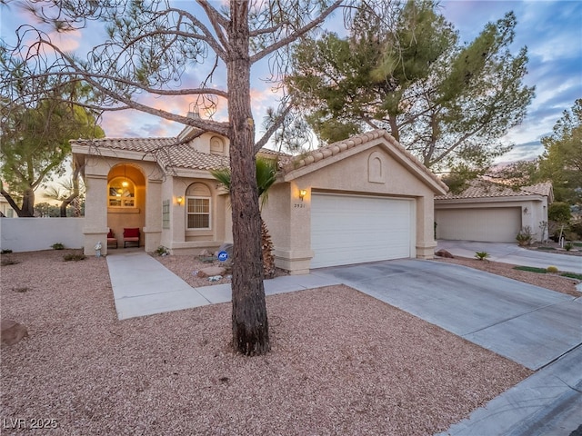 2521 Seascape Dr, Las Vegas, NV 89128 - mediterranean / spanish house featuring stucco siding, concrete driveway, a tile roof, and a garage