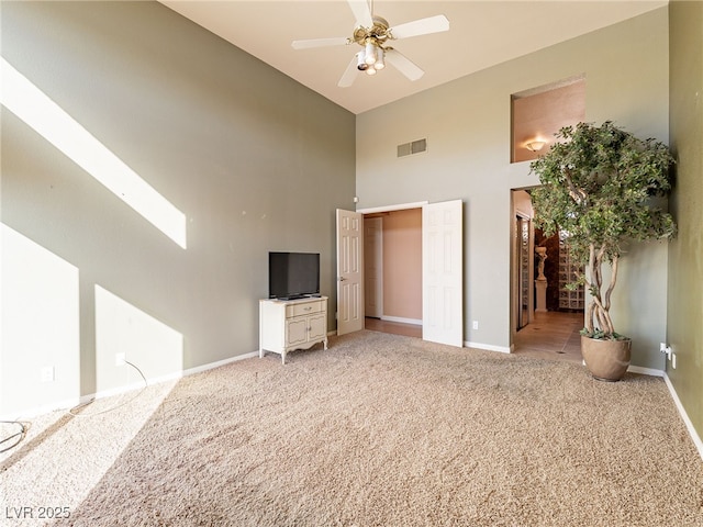 2521 Seascape Dr, Las Vegas, NV 89128 - unfurnished bedroom featuring a towering ceiling, light carpet, baseboards, and ceiling fan