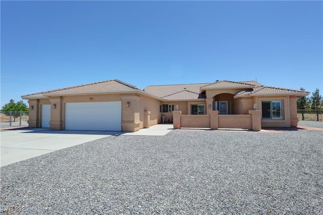 1361 Moose St, Pahrump, NV 89048 - mediterranean / spanish home featuring stucco siding, a tiled roof, an attached garage, and concrete driveway