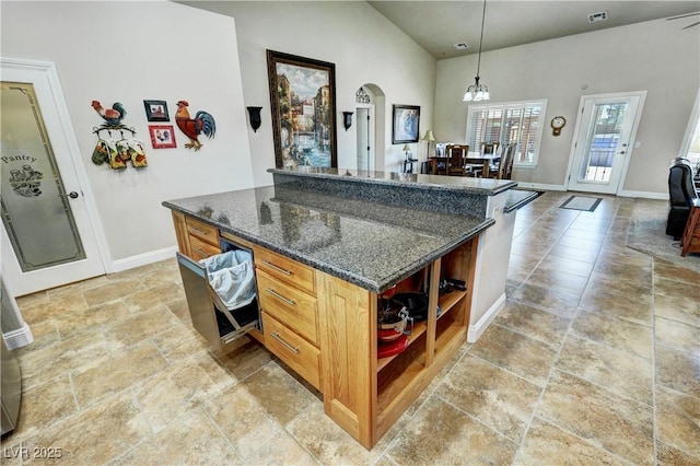 1361 Moose St, Pahrump, NV 89048 - kitchen featuring open shelves, baseboards, hanging light fixtures, arched walkways, and dark stone countertops