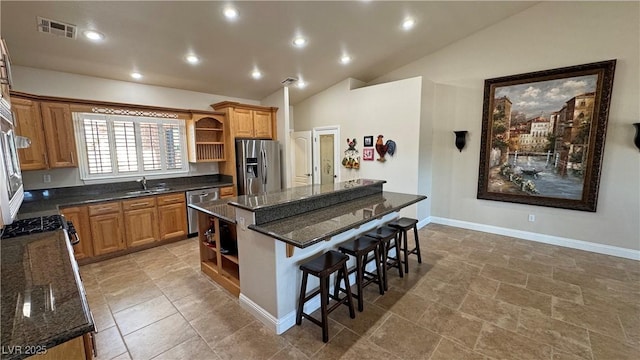 1361 Moose St, Pahrump, NV 89048 - kitchen with open shelves, appliances with stainless steel finishes, a sink, a center island, and a breakfast bar area