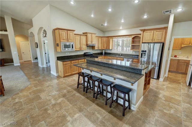 1361 Moose St, Pahrump, NV 89048 - kitchen with appliances with stainless steel finishes, a sink, open shelves, arched walkways, and a kitchen bar