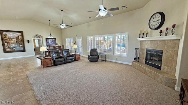 1361 Moose St, Pahrump, NV 89048 - living room featuring a ceiling fan, a tiled fireplace, baseboards, and high vaulted ceiling