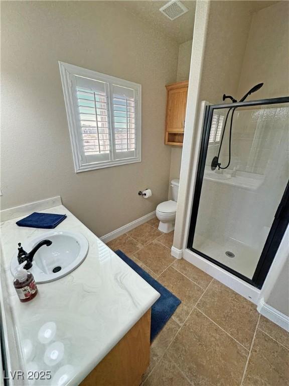 1361 Moose St, Pahrump, NV 89048 - full bath with vanity, a stall shower, toilet, baseboards, and tile patterned flooring