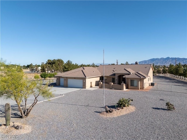 1361 Moose St, Pahrump, NV 89048 - view of front of property featuring a tile roof, an attached garage, driveway, stucco siding, and a mountain view