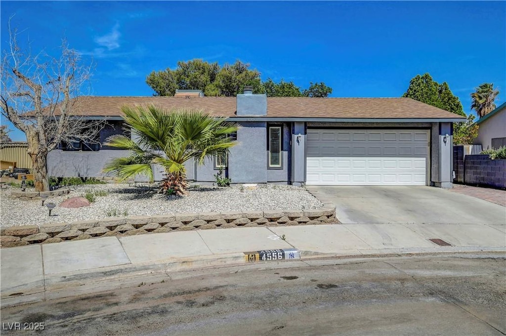 4556 Kenilworth Ct, Las Vegas, NV 89147 - ranch-style home with an attached garage, concrete driveway, a chimney, stucco siding, and a shingled roof