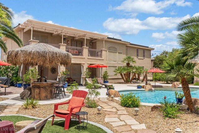 7001 Via Locanda Ave, Las Vegas, NV 89131 - rear view of house featuring a balcony, an outdoor pool, a patio, and stucco siding