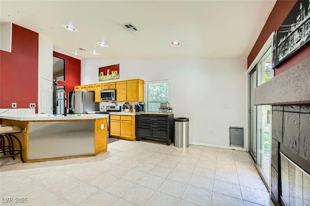 1905 Dakota Hills Ave, Las Vegas, NV 89123 - kitchen featuring appliances with stainless steel finishes, plenty of natural light, a kitchen bar, a peninsula, and high vaulted ceiling