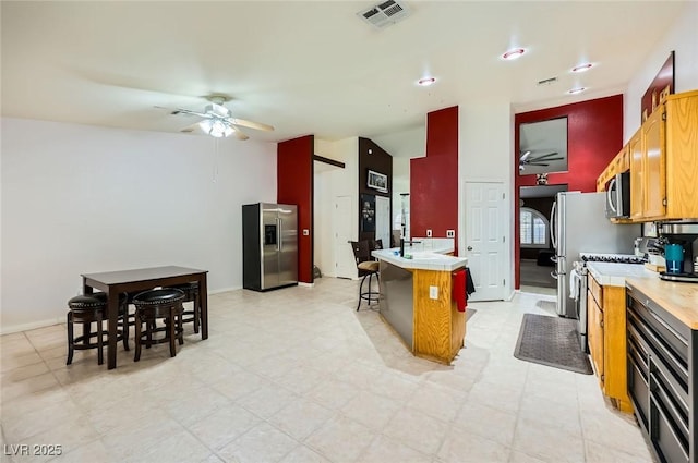 1905 Dakota Hills Ave, Las Vegas, NV 89123 - kitchen featuring a ceiling fan, appliances with stainless steel finishes, light countertops, vaulted ceiling, and a breakfast bar