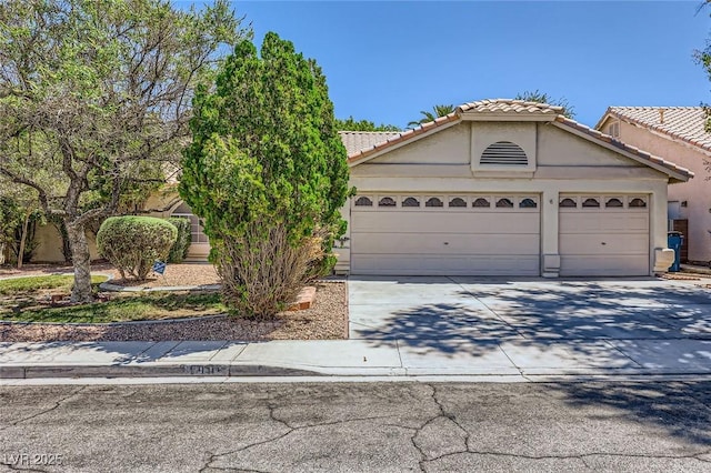 1905 Dakota Hills Ave, Las Vegas, NV 89123 - view of front of home featuring a garage, concrete driveway, stucco siding, and a tiled roof