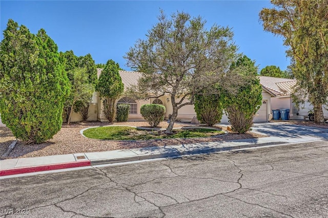 1905 Dakota Hills Ave, Las Vegas, NV 89123 - obstructed view of property with stucco siding, driveway, a tile roof, and a garage