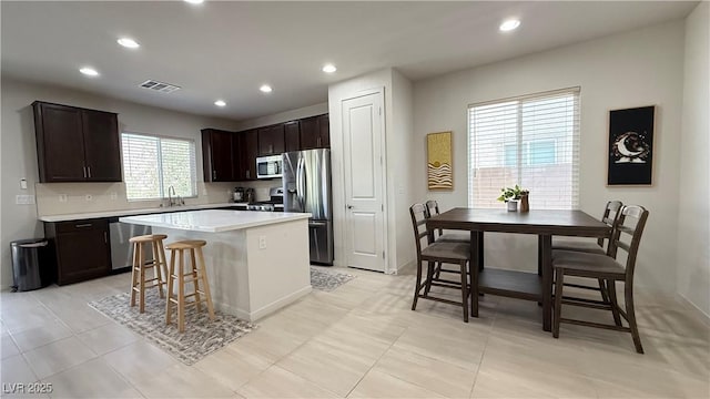 2924 Sunday Silence Rd, North Las Vegas, NV 89086 - kitchen featuring stainless steel appliances, a kitchen island, light countertops, recessed lighting, and dark brown cabinetry