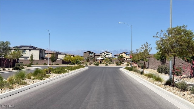 2924 Sunday Silence Rd, North Las Vegas, NV 89086 - view of asphalt street featuring street lights, a residential view, curbs, and a mountain view