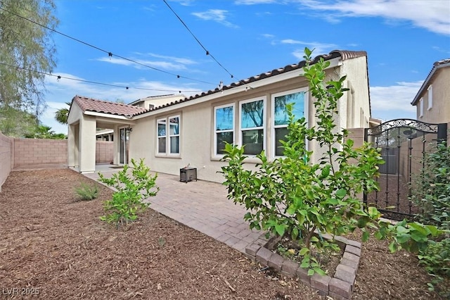 4020 Recktenwall Ave, North Las Vegas, NV 89081 - back of property with a tile roof, stucco siding, a fenced backyard, a gate, and a patio area