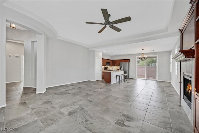 4020 Recktenwall Ave, North Las Vegas, NV 89081 - unfurnished living room with a glass covered fireplace, a ceiling fan, a chandelier, baseboards, and recessed lighting