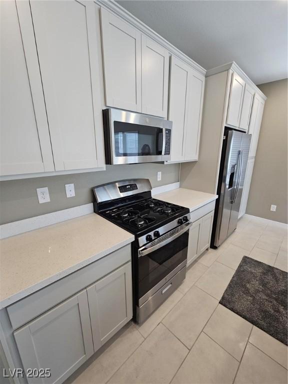 289 Aravalli Crest St, Henderson, NV 89015 - kitchen featuring appliances with stainless steel finishes, light tile patterned flooring, and white cabinets