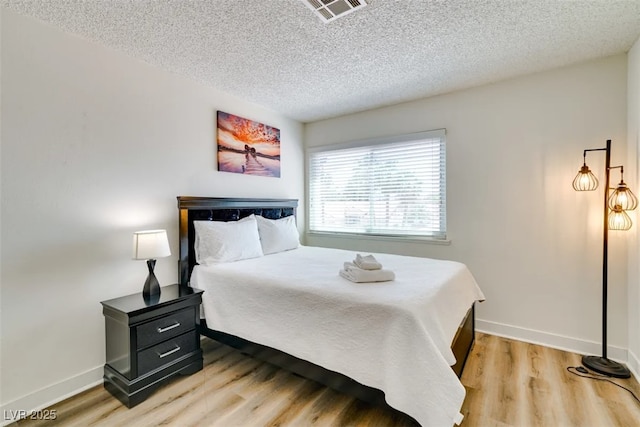 864 E Eldorado Ln, Las Vegas, NV 89123 - bedroom with a textured ceiling, light wood-style flooring, and baseboards
