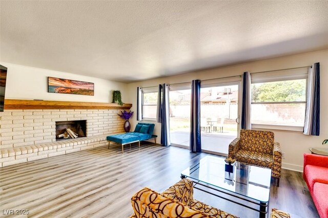 864 E Eldorado Ln, Las Vegas, NV 89123 - living room with wood finished floors, a textured ceiling, a fireplace, and baseboards