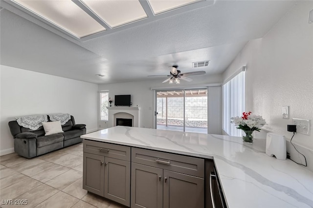 5639 Guiding Star Cir, North Las Vegas, NV 89031 - kitchen with gray cabinets, open floor plan, plenty of natural light, and a peninsula