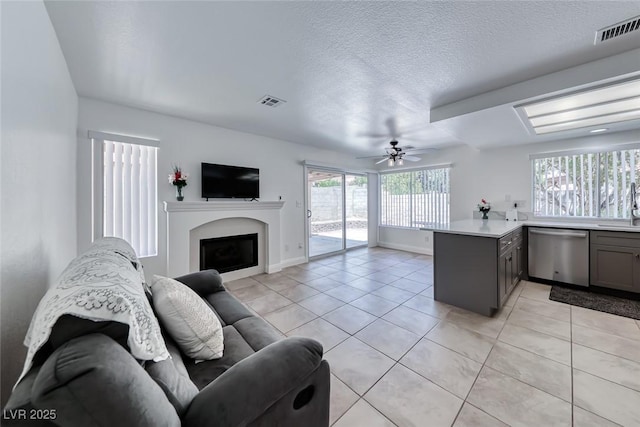 5639 Guiding Star Cir, North Las Vegas, NV 89031 - living area with ceiling fan, a fireplace, light tile patterned floors, and a textured ceiling