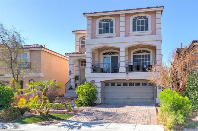 6714 Flamenco Ct, Las Vegas, NV 89139 - mediterranean / spanish-style home featuring stucco siding, decorative driveway, a garage, stairway, and a tile roof