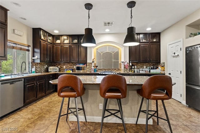 6714 Flamenco Ct, Las Vegas, NV 89139 - kitchen with stainless steel dishwasher, refrigerator, a kitchen island, decorative backsplash, and light stone countertops